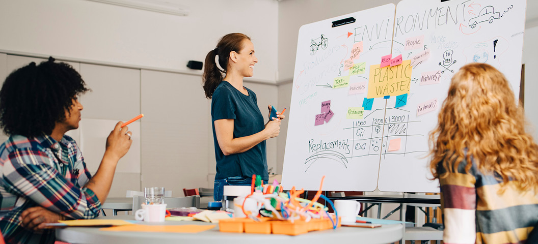 Glada och engagerade kursdeltagare samarbetar vid en whiteboard